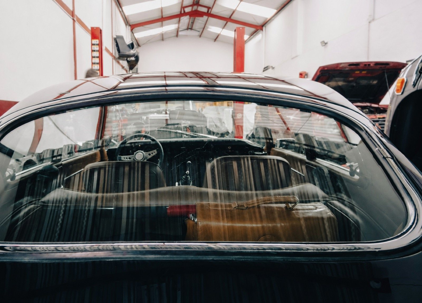 Clean rear window installed in a classic vehicle inside a workshop.