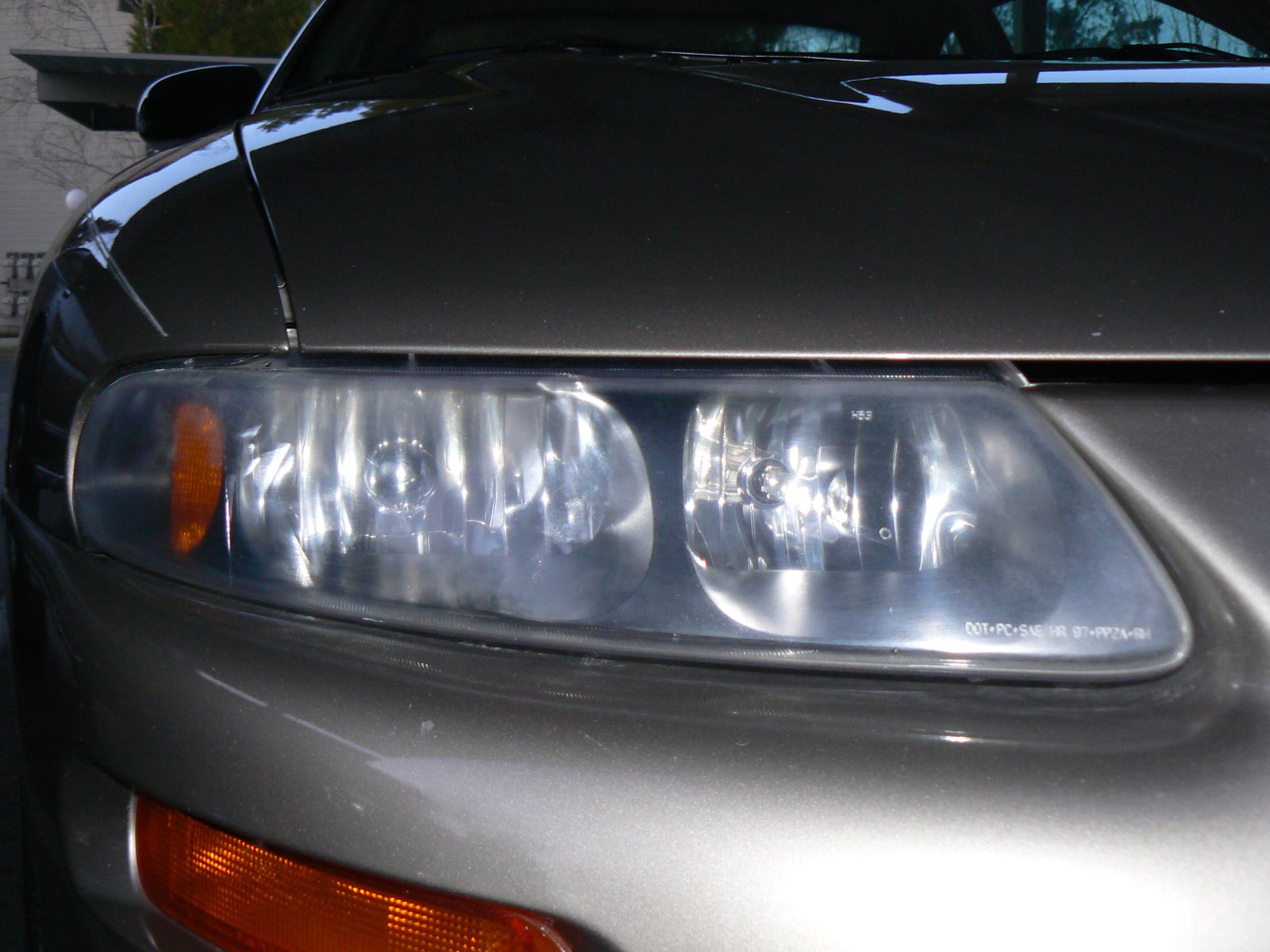 Completed headlight restoration result showing a clear installed lens after exterior surface correction.