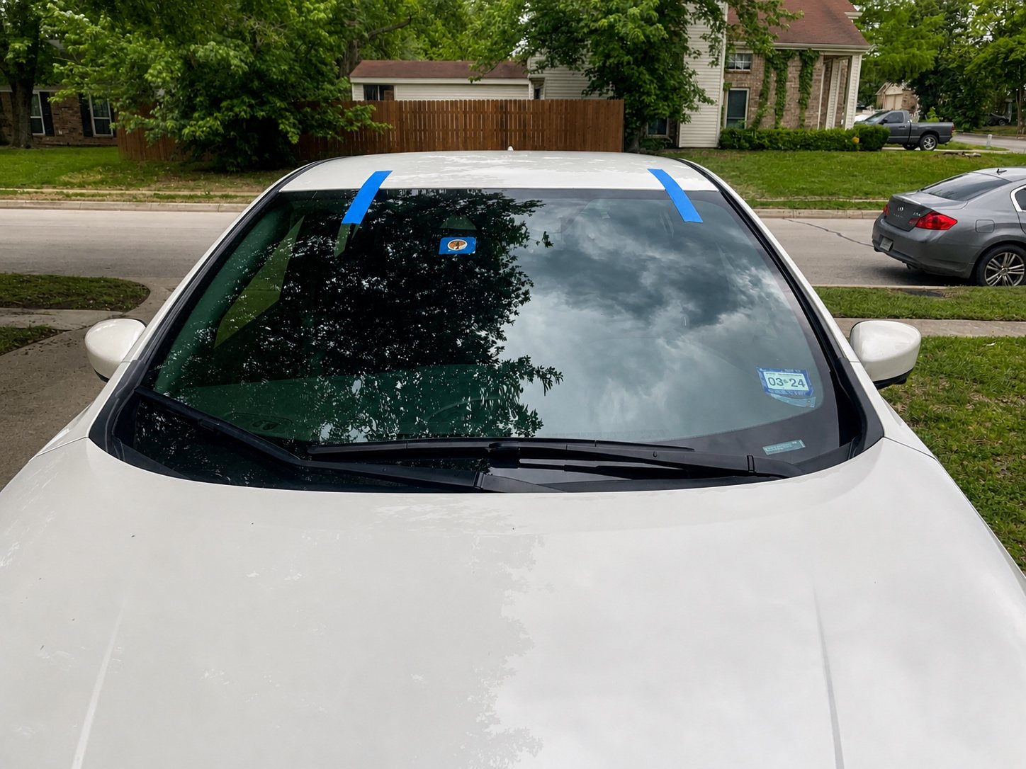 White vehicle after mobile windshield installation at a residential location.